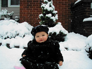 Amelia Xiaoqing, at age 9 months old, enjoys her first snow (a Florida rarity), in this photo from 2005.