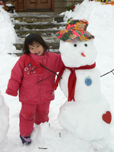 Kayla Xiu Yuan, 4 1/2 years old, of Ontario, Canada, poses by the snowman she made for her awaited sisted Anya, still in China.